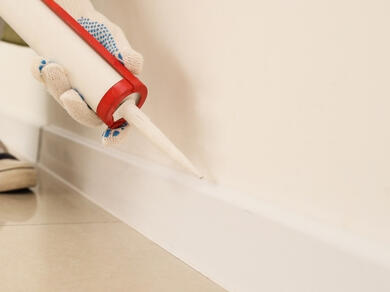 Applying sealant along a skirting board joint to create a neat and durable finish