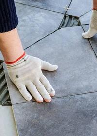 Installing floor tiles onto adhesive bed for a durable and level tiled surface