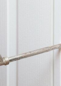 Close-up of expanding foam being injected into a gap between a wall and door frame with a foam gun, creating an insulated and airtight seal.